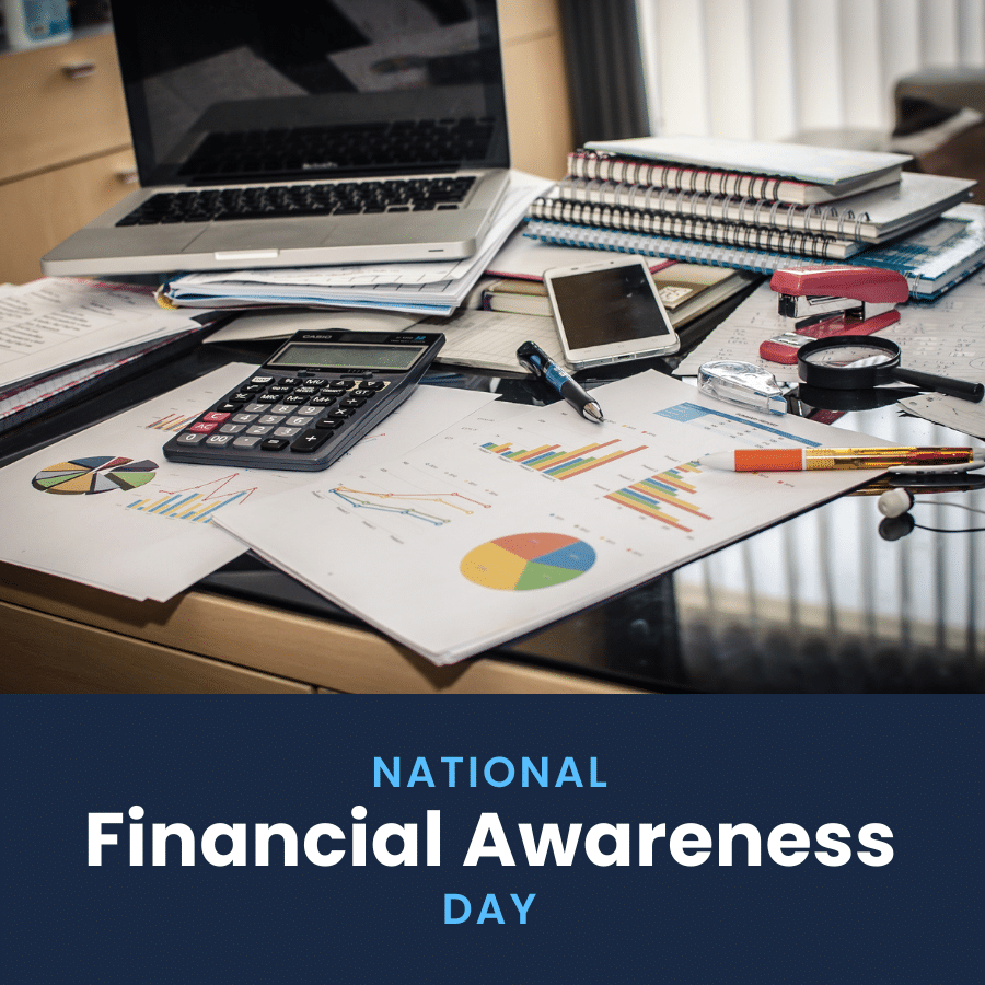 A messy desk with a laptop, calculator, phone, and lots of financial documents scattered around